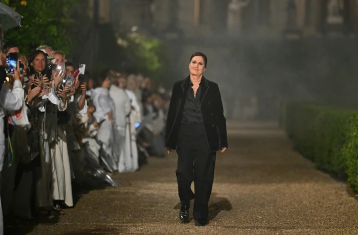 Maria Grazia Chiuri (c), directrice artistique de Dior, salue le public à la fin du défilé de la collection Dior Femme Croisière 26 à la Villa Albani Torlonia, à Rome, le 27 mai 2025