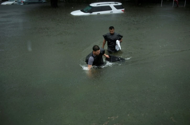Des gens tentent de sortir de l'eau dans les rues inondées de Galveston au Texas, après le passage de la tempête Harvey le 26 août 2017
