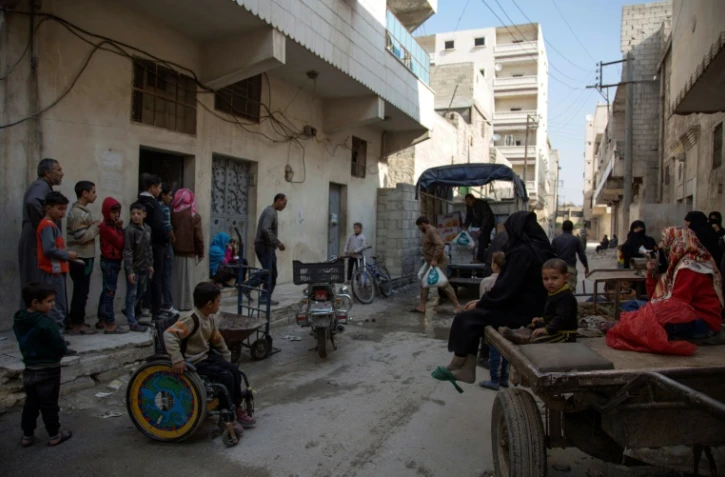 Des civils attendent l'aide alimentaire dans un quartier rebelle d'Alep, le 15 novembre 