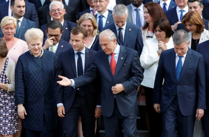 Le secrétaire général de l'OCDE Angel Gurria (c), le président français Emmanuel Macron (g, la présidente lituanienne Dalia Grybauskaite (2e g) et le président colombien Juan Manuel Santos, avec des participants à la réunion de l'OCDE, le 30 mai 2018à Paris