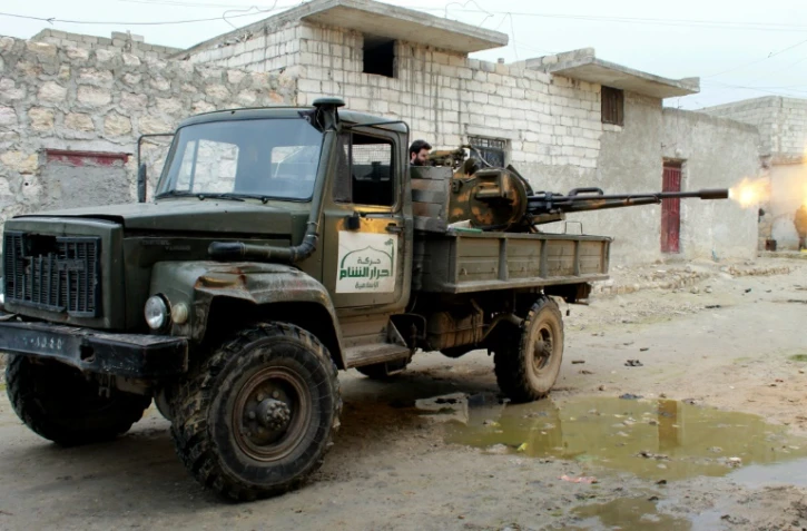 Un rebelle du groupe islamiste Ahrar al-Sham, faisant partie d'une coalition de groupes rebelles, tire sur des positions des forces gouvernementales syriennes près d'Alep, le 27 janvier 2014