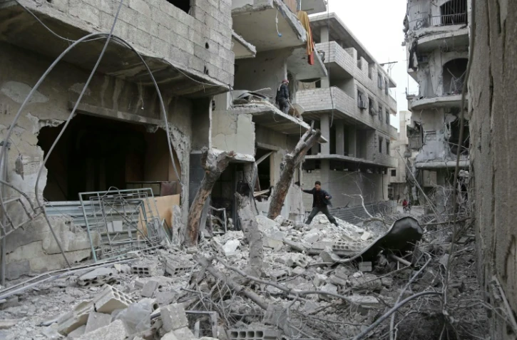 Un Syrien au milieu des énormes des destructions dans la localité de Hammouriyé, dans le fief rebelle de la Ghouta orientale, cible de violents bombardements du régime, le 22 février 2018