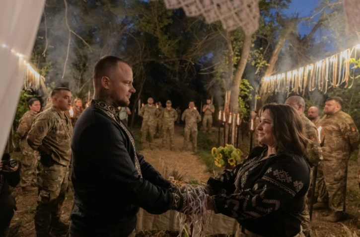 Le soldat Ice (g) et la médecin militaire Khomotchka (d) participent à leur "Mystérya", cérémonie mêlant traditions slaves préchrétiennes et rites orthodoxes, près d'Izium, dans la région de Kharkiv, en Ukraine, le 26 août 2026