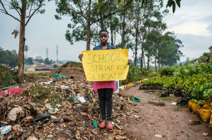 Leah Namugerwa, une Ougandaise de 15 ans, tient une pancarte prônant la grève pour alerter contre le réchauffement planétaire, le 4 septembre 2019 à Kampala.
