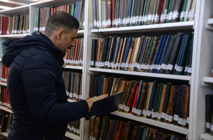 Un bibliothécaire consulte un livre dans la bibliothèque universitaire de Mossoul, ancien fief du groupe Etat islamique dans le nord de l’Irak, le 31 janvier 2022