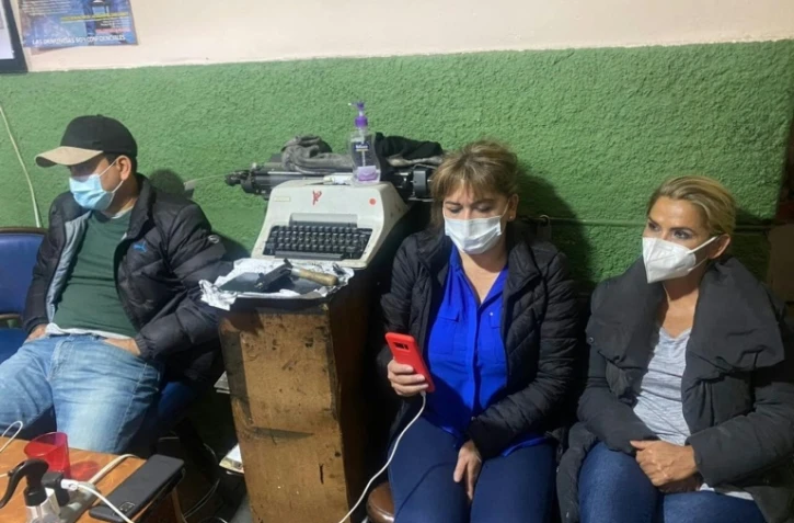 L'ancienne présidente par intérim bolivienne Jeanine Añez (D) avec sa fille Carolina Ribera et l'ancien ministre de l'Energie Rodrigo Guzman (G) dans les locaux de la police à La Paz le 14 mars 2021 