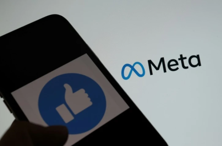 Un smartphone devant un écran d'ordinateur affichant le logo META, à Los Angeles le 28 octobre 2021
