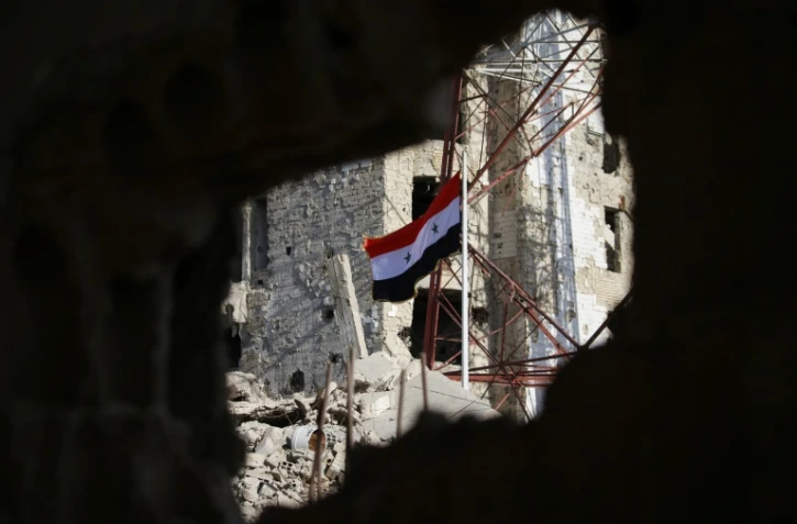 Le drapeau national syrien hissé par les forces de Bachar al-Assad dans le centre-ville de Deraa, berceau de la révolte contre son régime, le 12 juillet 2018