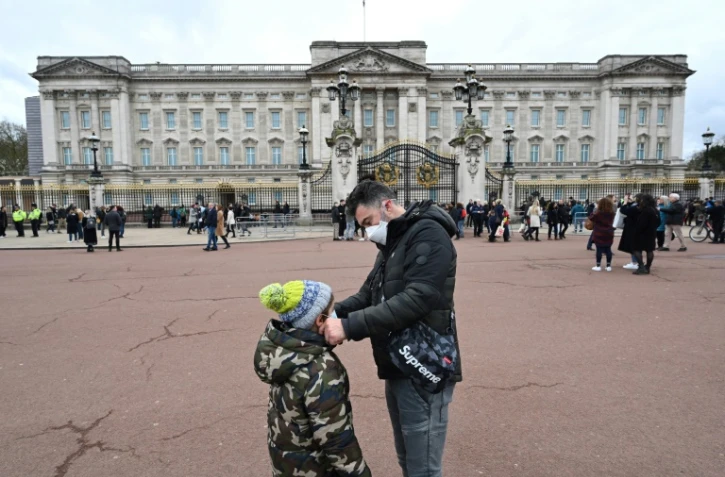 Un père ajuste le masque de protection de son fils, le 14 mars 2020 à Londres