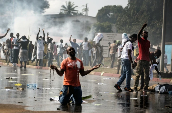 Un partisan de l'opposition gabonaise prie devant les forces de l'ordre à Libreville lors d'une manifestation de l'opposition contre la réélection d'Ali Bongo, le 31 août 2016