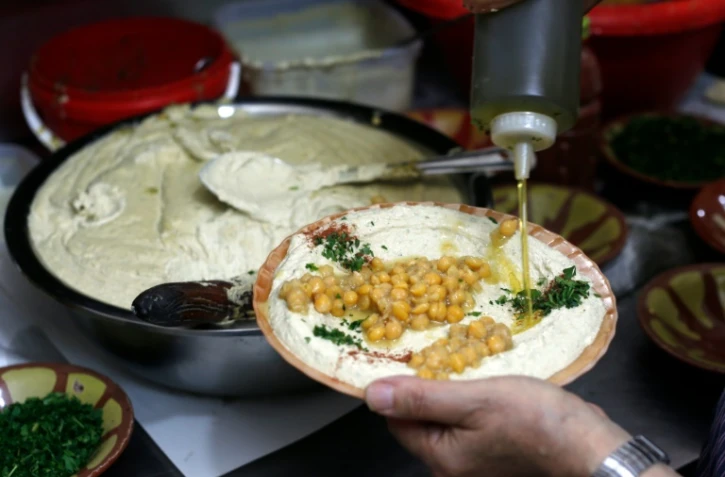 Un restaurateur palestinien prépare un plat de hoummous, purée froide à base de pois chiches, dans la vieille ville de Jérusalem, le 12 septembre 2015