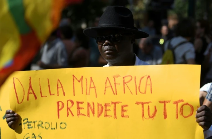 "De mon Afrique, vous prenez tout", une affiche lors d'une manifestation à Rome pour dénoncer la violente expulsion de réfugiés squattant un immeuble à Rome, le 26 août 2017