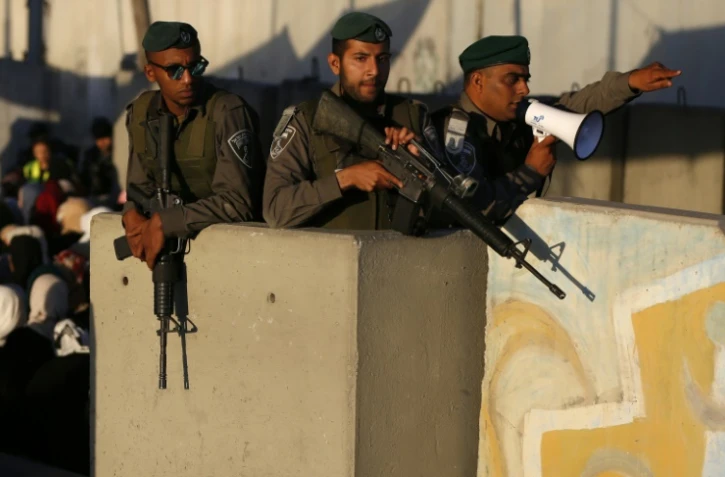 Des soldats israéliens surveillent des Palestiniens qui passent par le checkpoint de Qalandia, le 17 juin 2016