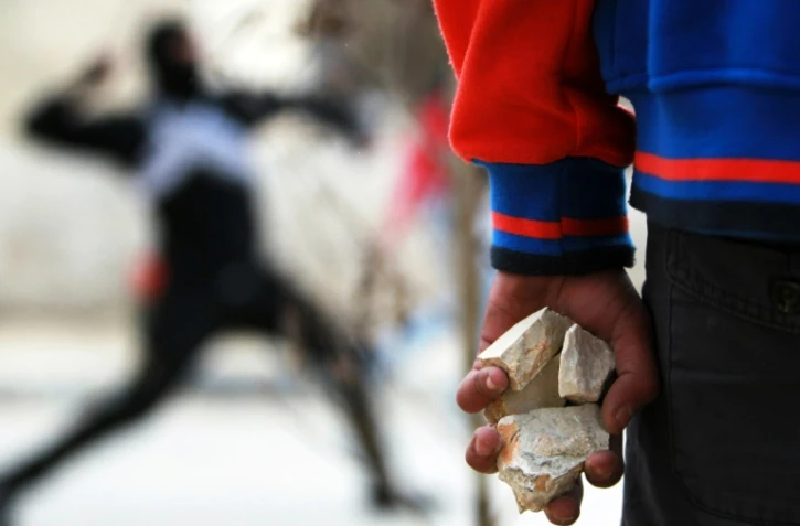Un Palestinien tient des pierres dans ses mains lors d'affrontements avec des soldats israéliens, le 13 février 2015, près de Bethléem.