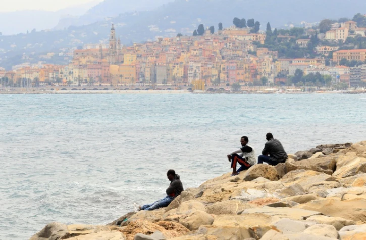 Des migrants regardent la mer à Vintimille, à la frontière franco-italienne, tout près de la ville française de Menton, en arrière-plan, le 13 juin 2015