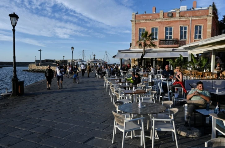 Des habitants et des touristes profitent des terrasses dans la vieille ville de La Canée, dans le nord-ouest de la Crète, le 13 mai 2021