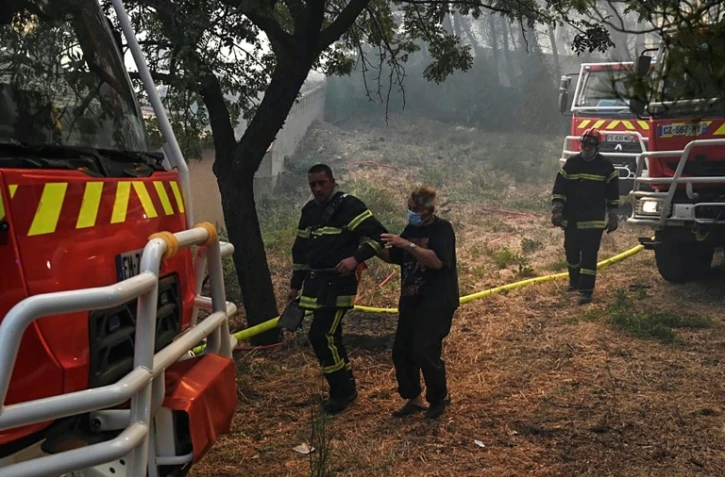Un homme âgé est évacué par les pompiers lors d?un incendie de forêt à Martigues, le 24 août 2020