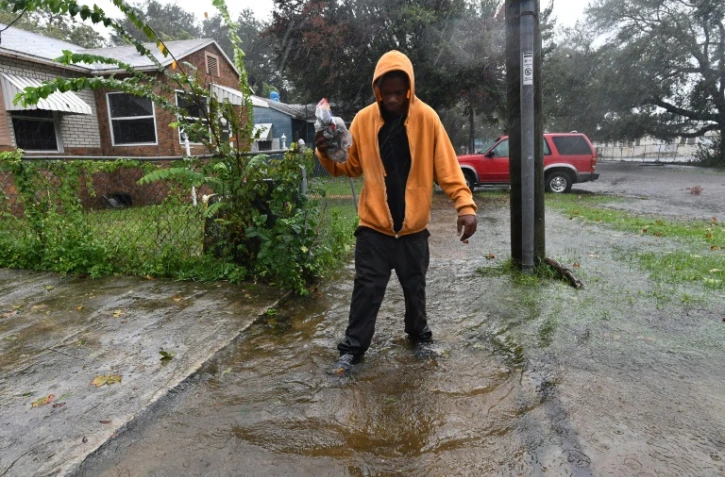 Un habitant de Jacksonville marche dans une rue inondée, après le passage de l'ouragan Matthew, le 7 octobre 2016 en Floride