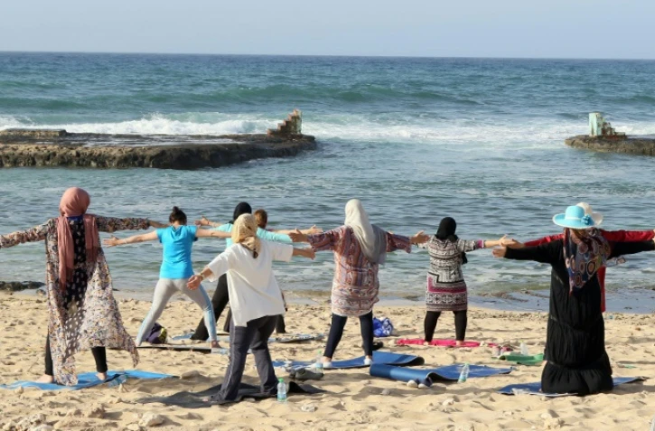 Des femmes libyennes participent à une séance de yoga sur une plage de Tripoli, le 14 avril 2016