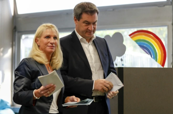 Markus Soeder, ministre-président de Bavière, membre de l'Union chrétienne-sociale (CSU), vote aux élections régionales avec sa femme Karin Soeder à Nuremberg, le 14 octobre 2018