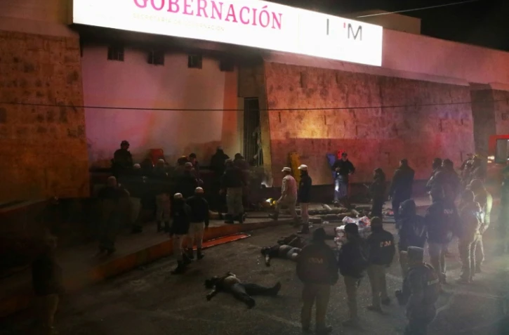 Des pompiers et des policiers secourent des migrants après un incendie meurtrier dans un centre de rétention à Ciudad Juarez au Mexique le 27 mars 2023