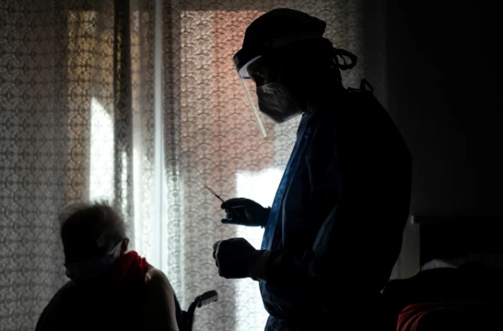 Une femme de 80 ans (g) reçoit une dose de vaccin Moderna contre le Covid-19 à Dronero, dans le nord-ouest de l'Italie, le 13 mars 2021