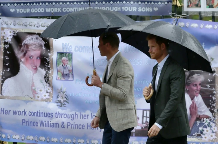 Les prince William et Harry regardent les hommages à leur mère Diana accrochés à la grille de Kensington Palace, où elle résidait à Londres, le 30 août 2017