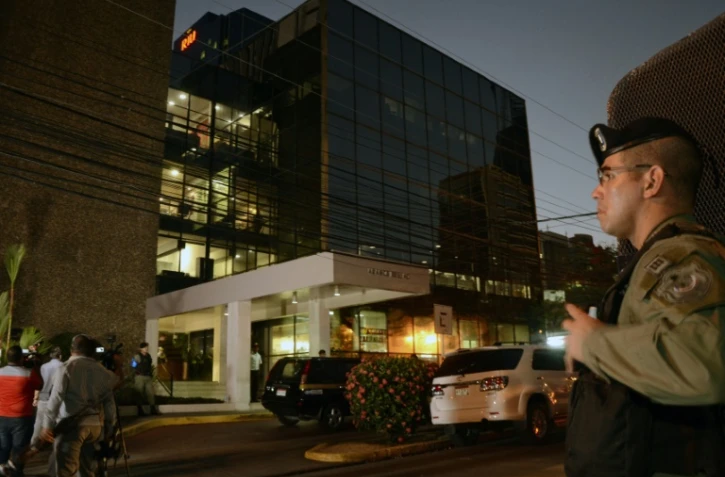 Un policier au pied des bureaux du cabinet d'avocats Mossack Fonseca lors de la perquisition, le 12 avril 2016 Ă Panama