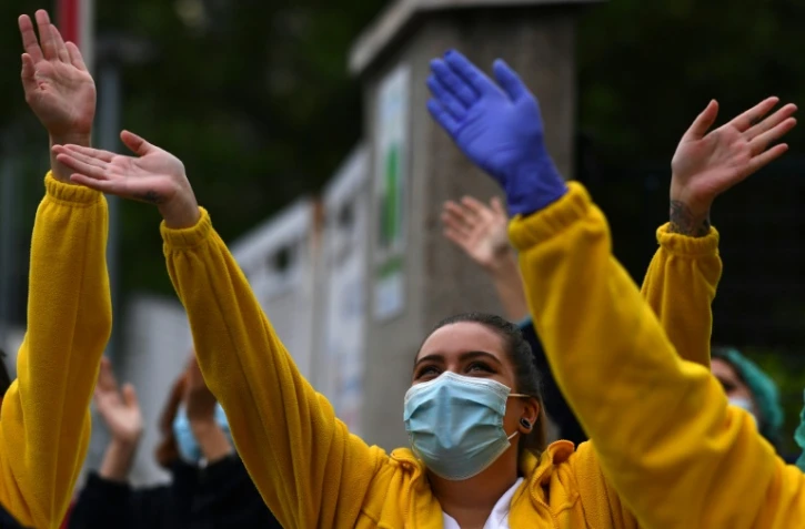 Des soignants de l'hôpital Gregorio Maranon à Madrid remercient les passants qui les applaudissent devant l'établissement, le 27 avril 2020