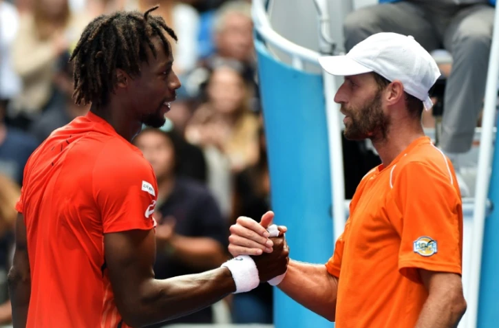 Gaël Monfils (g) serre la main de Stéphane Robert, éliminé de l'Open d'Australie, le 23 janvier 2016 à Melbourne
