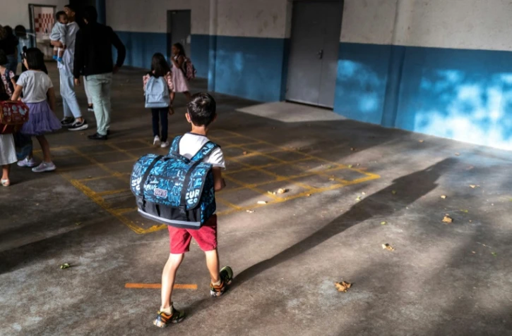 Un élève,  cartable sur le dos, se dirige vers sa classe dans l'école Molière à Toulouse, le 4 septembre 2023
