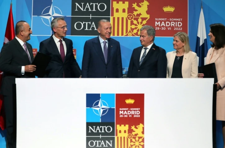 Le secrétaire général de l'Otan, Jens Stoltenberg (2e G), le président turc, Recep Tayyip Erdogan (C) et le président finlandais, Sauli Niinisto (3e G) après la signature d'un memorandum à Madrid, le 28 juin 2022