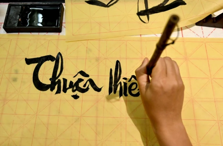 Hoang Thi Thanh Huyen apprend la calligraphie chez le calligraphe Nguyen Thanh Tung, le 15 mai 2025 à Hanoï, au Vietnam
