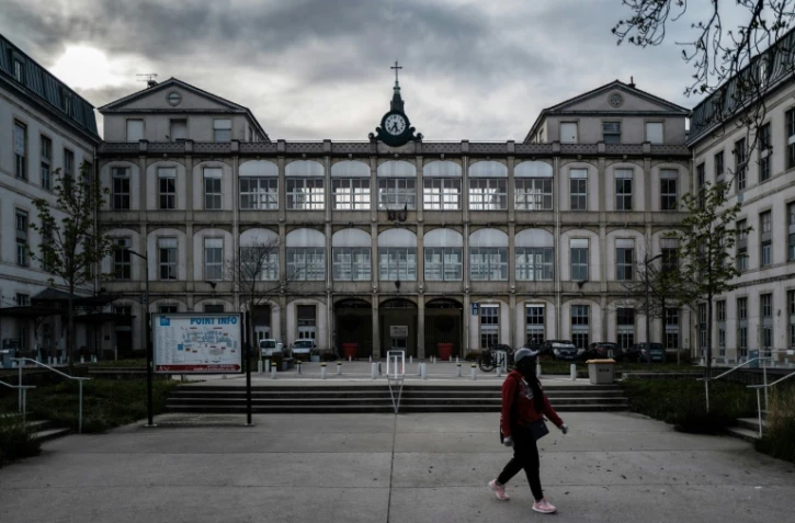 Une personne passe devant l'hĂ´pital de la Croix-Rousse Ă Lyon, le 27 mars 2020
