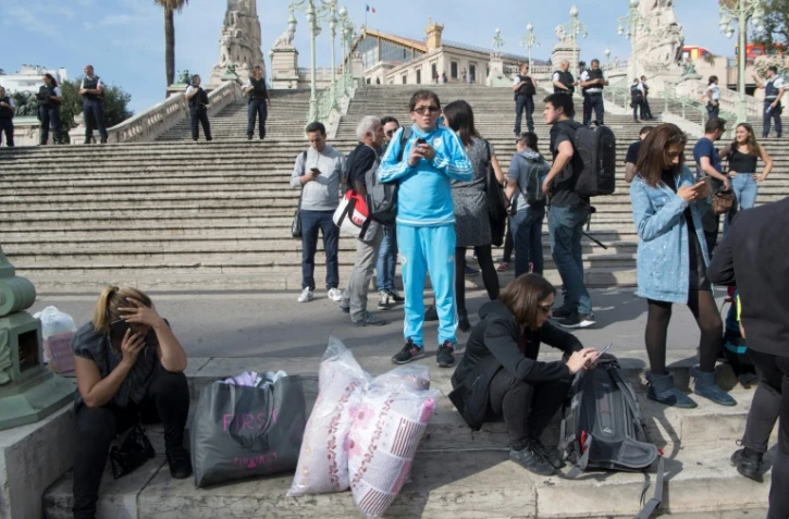 Des gens au pied de la gare Saint-Charles à Marseille le 1er octobre 2017 après l'attaque au couteau qui a fait deux morts