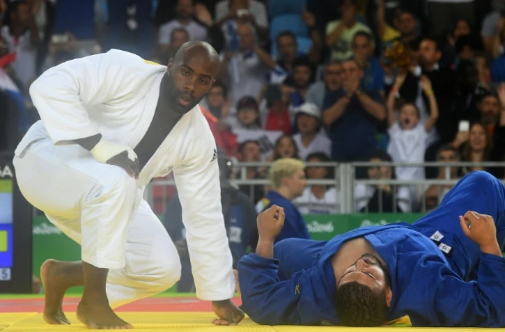 Teddy Riner (blanc) face à l'Algérien Mohammed Amine Tayeb (bleu) lors des qualifications pour les quarts au tournoi olympique de judo, le 12 août 2016 à Rio