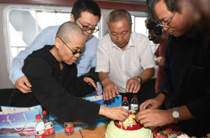 Liu Xia, veuve du prix Nobel de la paix Liu Xiaobo, prépare des fleurs avant que les cendres de son époux ne soient dispersées en mer, le 15 juillet 2017 au large de Dalian eb Chine. Photographie fournie par le service de presse de Shenyang