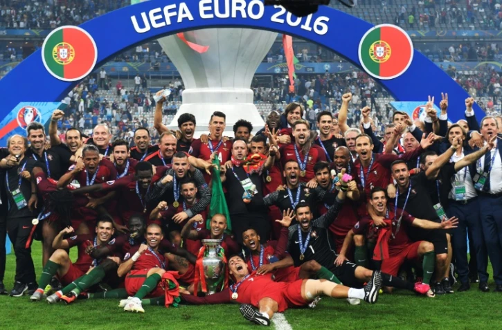 Les joueurs et personnels de l'équipe de football portugaise posent avec le trophée après avoir remporté la finale de l'Euro-2016, le 10 juillet 2016 au Stade de France, à Saint-Denis, près de Paris