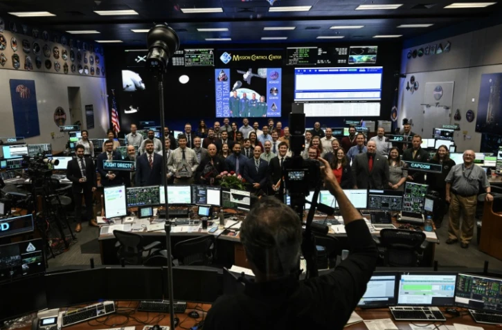 Le personnel de la Nasa pose pour une photo de groupe au centre de contrĂ´le du centre spatial Johnson Ă Houston, Etats-Unis, le 6 avril 2026