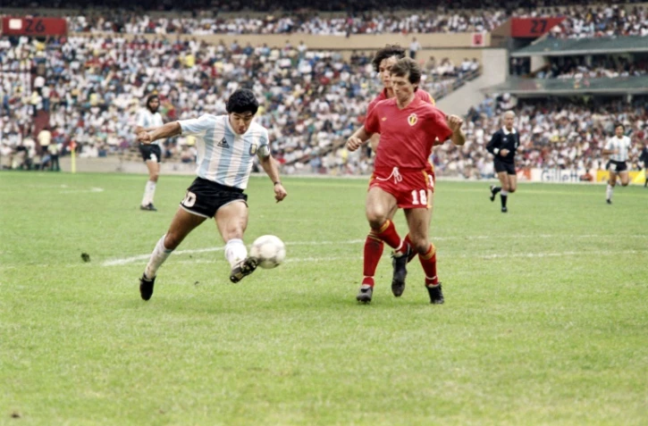 L'Argentin Diego Maradona (g) à la lutte avec les défenseurs belges lors des demi-finales du Mondial 1986, à Mexico, le 25 juin
