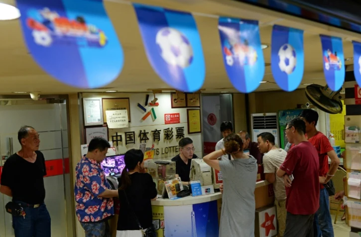 Des parieurs dans une boutique de loto sportif à Shanghai, le 2 juillet 2018