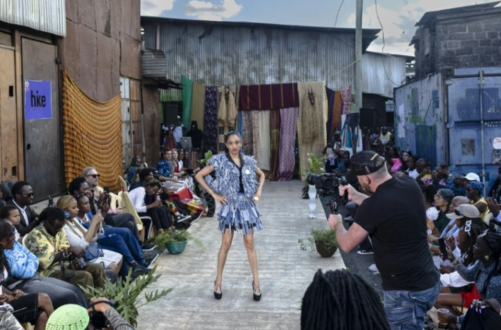 Des mannequins présentent des tenues de créateurs locaux spécialisés dans le recyclage de tissus et de vêtements mis au rebut, lors du défilé de mode Gikomba Runway Edition à Nairobi, le 10 octobre 2025 au Kenya