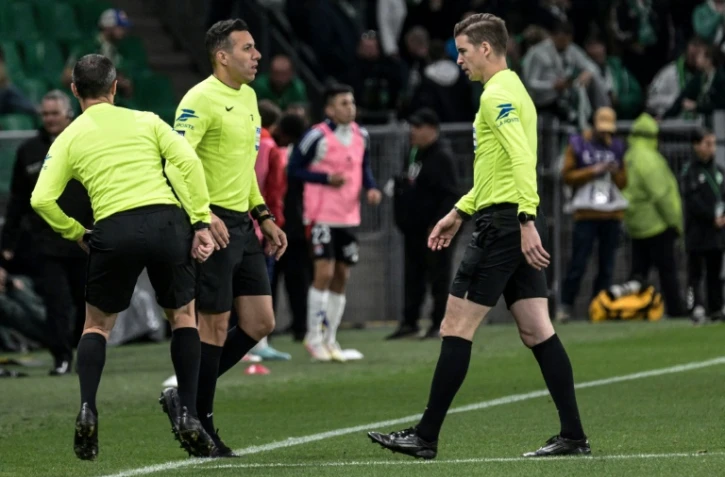 L'arbitre de touche Mehdi Rahmouni (au centre), touché par un projectile durant le derby Saint-Etienne-Lyon au stade Geoffroy-Guichard le 20 avril 2025. 