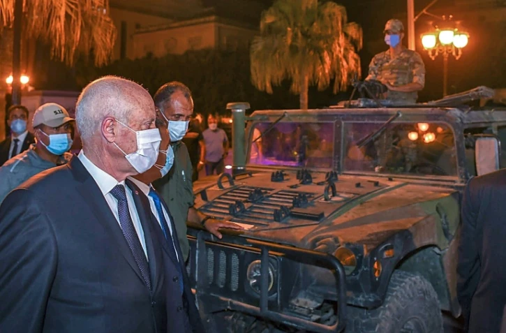 Une photo du compte Facebook de la présidence tunisienne le 26 juillet 2021 montre le président tunisien Kais Saied passant devant un véhicule militaire alors qu'il se promène sur l'avenue Habib Bourguiba, dans le centre de Tunis, après avoir évincé le Premier ministre et suspendu le Parlement pour 30 jours