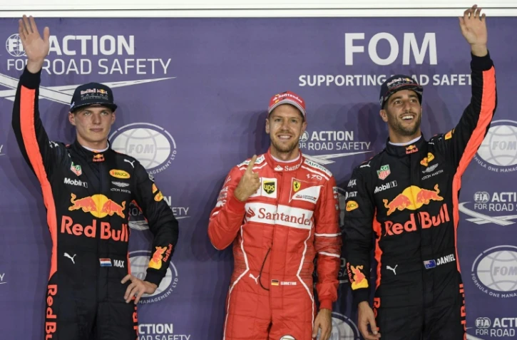 Sebastian Vettel (C) après sa victoire, entre Max Verstappen (G) et Daniel Ricciardo, à Singapour le 16 septembre 2017 