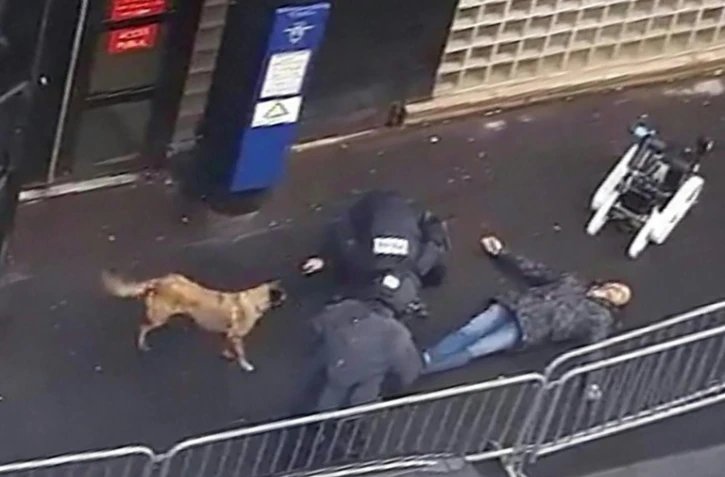 Une capture d'écran d'une vidéo obtenue par l'AFP montre la police et un robot démineur autour du cadavre d'un homme abattu par la police devant le commissariat de la Goutte-d'Or à Paris, le 7 janvier 2016