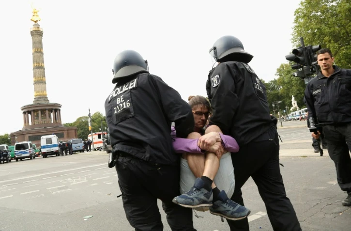 Un protestataire de la manifestation "anticorona" est interpellé par des policiers dans le centre de Berlin, le 30 août