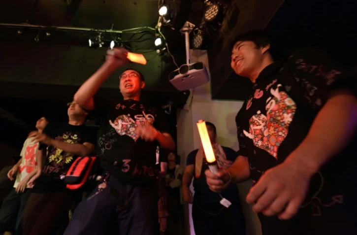 Des adultes assistent au spectacle d'un groupe de chanteuses "idoles", des fillettes se produisant sur scène, le 29 juillet 2017 dans un club à Tokyo