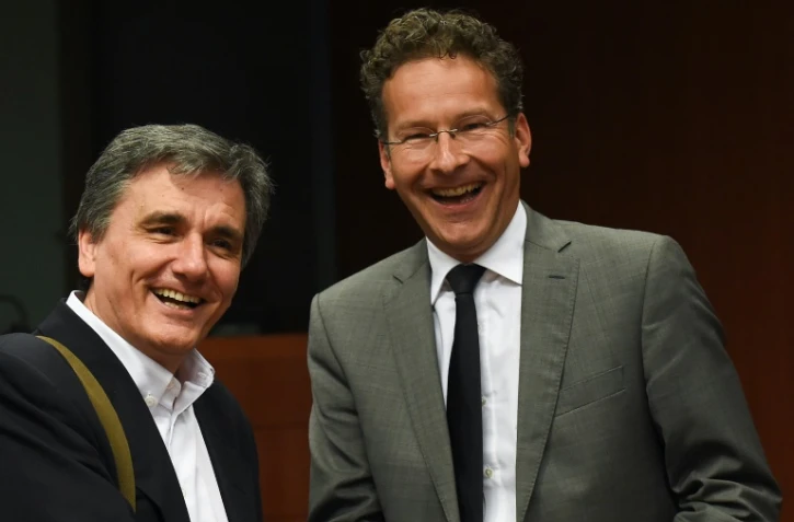 Le ministre grec des Finances Euclid Tsakalotos (g) sert la main du président de l'Eurogroupe Jeroen Dijsselbloem à Bruxelles, le 9 mai 2016 