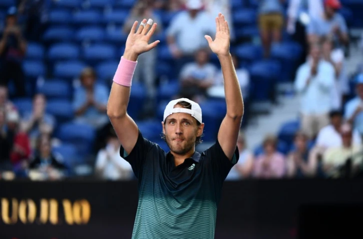 Le Français Lucas Pouille exulte bras levés après sa victoire face au Canadien Milos Raonic en quarts de finale de l'Open d'Australie, le 23 janvier 2019 à Melbourne 